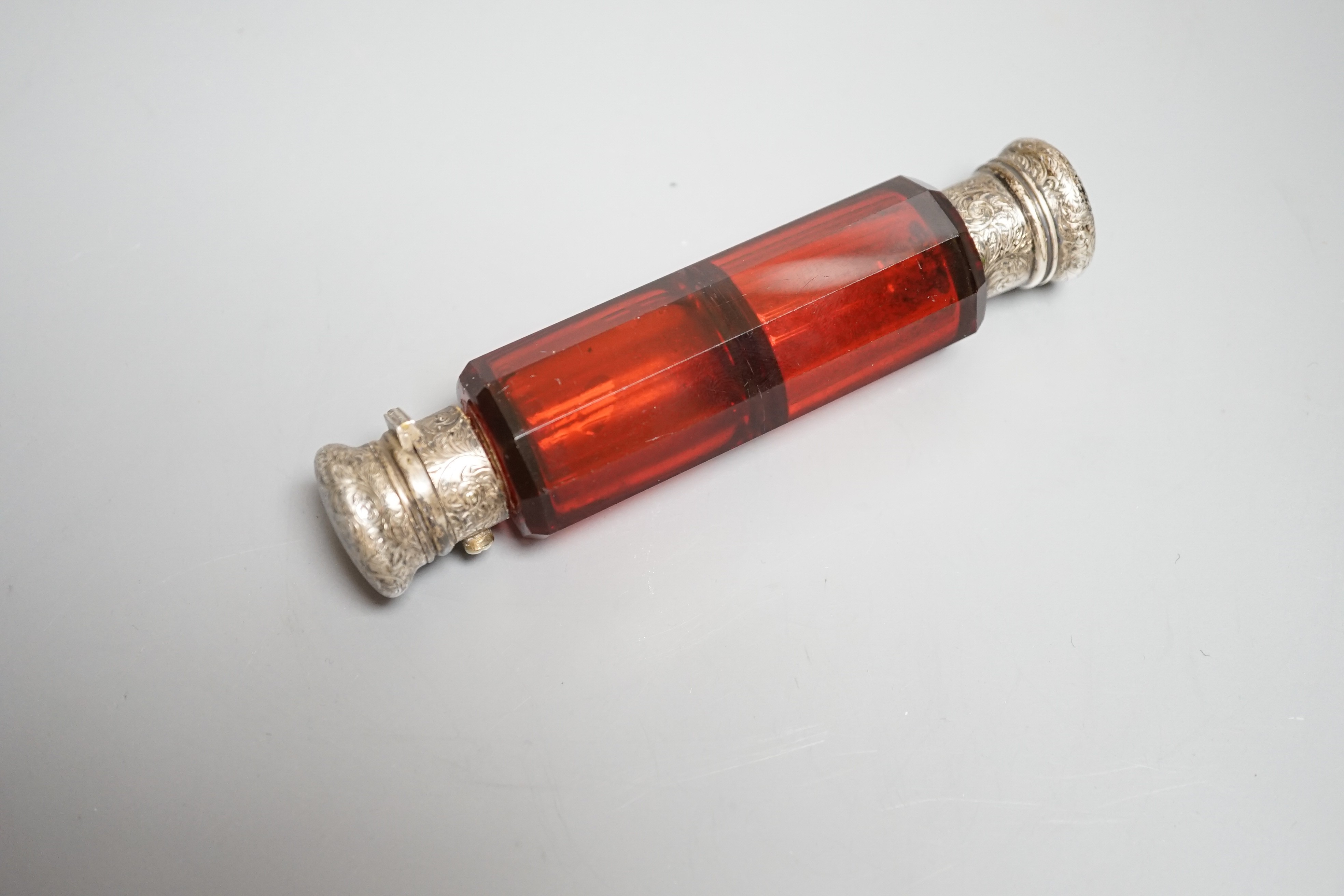 A Victorian engraved white metal and ruby glass double ended scent bottle, 12.7cm.